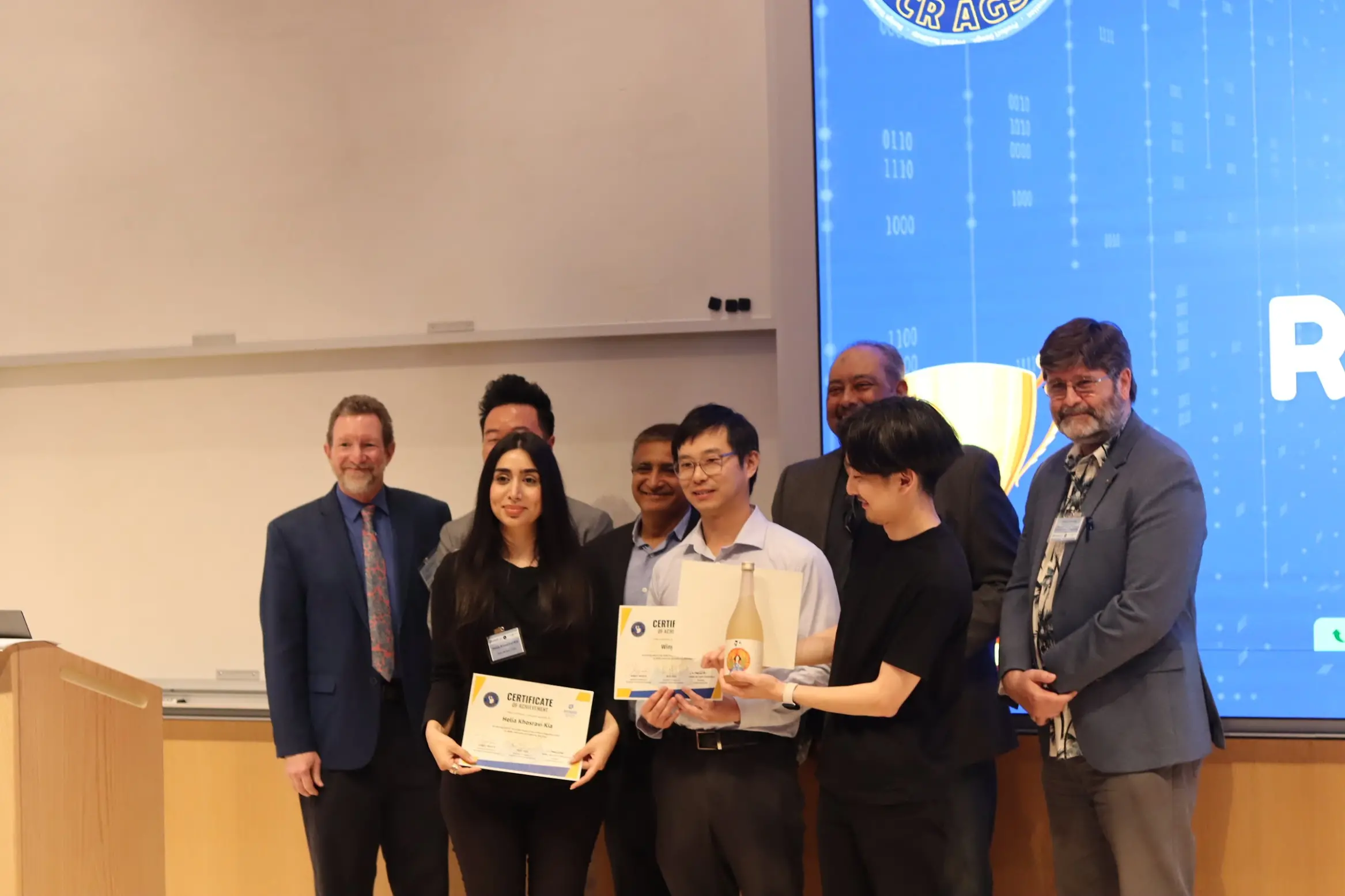 A group of people taking pictures together and giving a gift